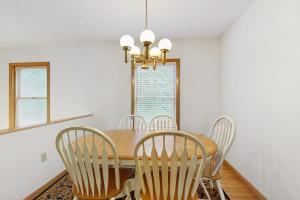 a dining room table with chairs and a chandelier at Townhome w/ Bonus Loft, High-Speed WiFi, Partial AC & Full Kitchen in Bar Harbor