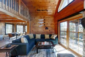 a living room with a blue couch in a cabin at Stunning & Spacious Log Cabin in the Woods in Boothbay Harbor