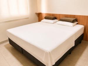 a large white bed in a room at Vêneto Flat Residence (AP-02) in Primavera do Leste