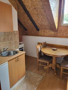 a kitchen with a sink and a table with chairs at Vila Arena in Mandići