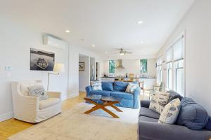a living room with two blue couches and a kitchen at Waterfront, walkable home with beautiful kitchen & washer/dryer - dog-friendly in Camden