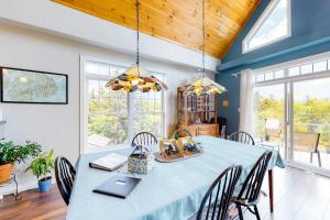 a dining room with a blue table and chairs at Secluded hilltop home with beautiful Cadillac Mountain view and multiple decks in Bar Harbor