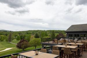 a restaurant with tables and chairs on a balcony at The Outpost by Windham Mountain Club in Windham +25 photos