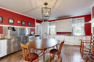 a kitchen with a wooden table and red walls at National Historic Landmark Home in Wiscasset Village w/ Complimentary Tour in Wiscasset