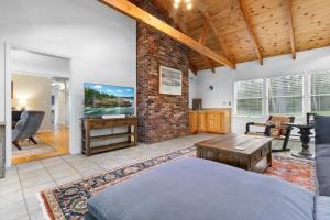 a living room with a bed and a brick wall at Tranquil private riverfront home w/ tidal dock & large yard in Boothbay