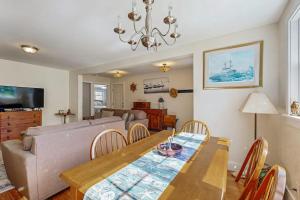 a living room with a table and a couch at Coastal bungalow with large yard, beautiful kitchen, & great location in Boothbay Harbor