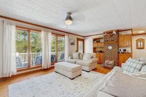 a living room with two couches and a table and chairs at Secluded waterfront home with private dock, outdoor dining, firepit, WiFi & W/D in Orland