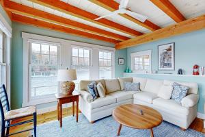 a living room with a white couch and a table at Enchanting Oceanfront Cottage with Breathtaking Views and Modern Comforts in East Boothbay