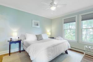 a bedroom with a white bed and two windows at Waterfront, walkable home with beautiful kitchen & washer/dryer - dog-friendly in Camden +11 photos