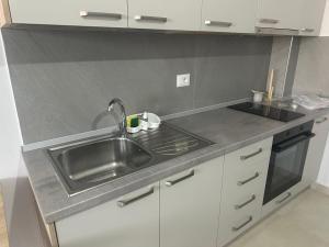 a kitchen with a sink and a stove at Apartament E&G in Rrogozhinë