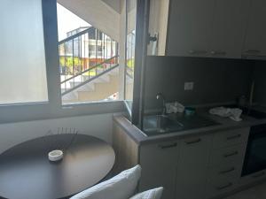 a kitchen with a table and a sink and a window at Apartament E&G in Rrogozhinë