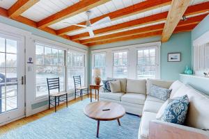 a living room with a white couch and a table at Enchanting Oceanfront Cottage with Breathtaking Views and Modern Comforts in East Boothbay