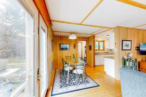 a dining room with a table and a kitchen at Dog-friendly ocean-view home with grill, wood stove, deck, washer/dryer, & AC in Southwest Harbor