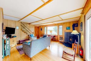 a living room with a couch and a television at Dog-friendly ocean-view home with grill, wood stove, deck, washer/dryer, & AC in Southwest Harbor