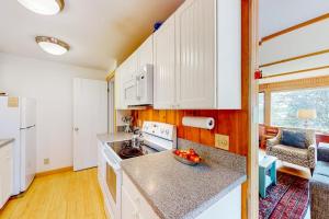 a kitchen with white cabinets and a bowl of fruit on the counter at Dog-friendly ocean-view home with grill, wood stove, deck, washer/dryer, & AC in Southwest Harbor +30 photos