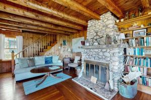 a living room with a fireplace and a couch at Ocean Point Colony Home w/ Sunroom & Sweeping Ocean Views, Dog-friendly in East Boothbay