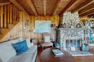 a living room with a couch and a fireplace at Ocean Point Colony Home w/ Sunroom & Sweeping Ocean Views, Dog-friendly in East Boothbay