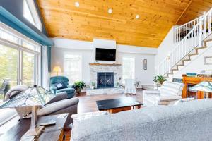 a living room with a couch and a fireplace at Secluded hilltop home with beautiful Cadillac Mountain view and multiple decks in Bar Harbor