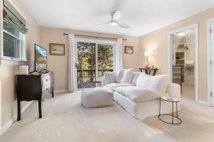 a living room with a white couch and a tv at Tranquil private riverfront home w/ tidal dock & large yard in Boothbay