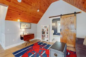 a room with a living room with a wooden ceiling at Luxurious waterfront home with deck, firepit, hot tub, fireplace, & pool table in Boothbay
