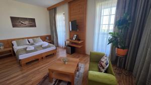 a hotel room with a bed and a living room at Vila Araya Mlynica in Mlynica