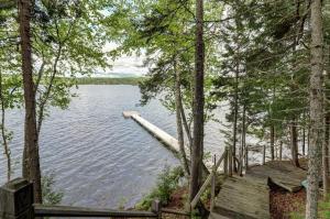 a view of a lake through the trees at Lakefront Chalet-Style Home with Large Deck, a Dock & Beautiful Lake Views in Greenville +31 photos