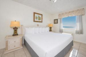 a bedroom with a large white bed and a window at Driftwood Towers 5A in Gulf Shores +25 photos