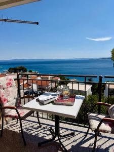 a table on a balcony with a view of the ocean at Studio Apartments Ivo in Baška Voda