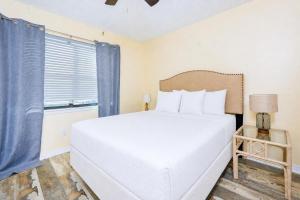 a bedroom with a white bed and a window at Lei Lani 108 condo in Orange Beach