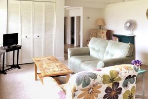 a living room with a couch and a table at Ocean-view cottage near beach with deck, grill, & full kitchen in Bristol