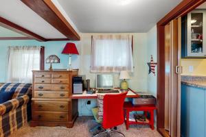 a bedroom with a desk with a computer and a bed at Secluded lakefront cottage great views, dock & boat launch in Ellsworth