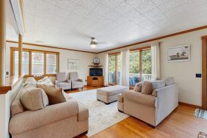a living room with two couches and a tv at Secluded waterfront home with private dock, outdoor dining, firepit, WiFi & W/D in Orland