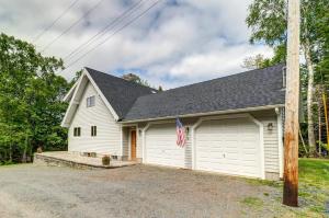 a white house with a garage with a flag at Lakefront Chalet-Style Home with Large Deck, a Dock & Beautiful Lake Views in Greenville