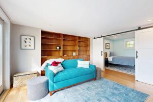 ein Wohnzimmer mit einer blauen Couch und ein Schlafzimmer in der Unterkunft Stunning riverfront home, hot tub, BBQ, and washer & dryer in Edgecomb