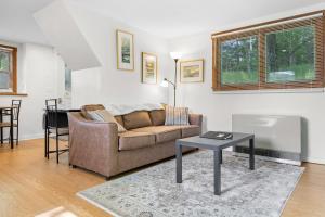 a living room with a couch and a table at Two-Level Unit w/ Patio, Deck, Firepit, Private Washer/ Dryer, and Free WiFi in Seal Harbor