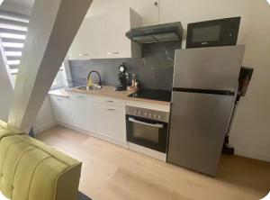 a kitchen with a stainless steel refrigerator and a sink at Nid Douillet in Forbach