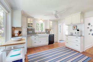 a large kitchen with white cabinets and a large window at Tranquil Seaside Cottage with Spectacular Views, Wifi & Washer/Dryer in Boothbay +17 photos