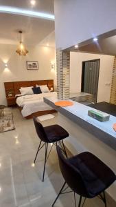 a bedroom with two beds and two black chairs at PaoLia Meublé 3 in Cotonou