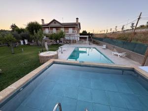 a swimming pool in a yard next to a house at Sueña TOLEDO- Piscina in Toledo