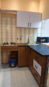 a kitchen with wooden cabinets and a counter top at PaoLia Meublé 3 in Cotonou