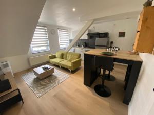 a kitchen and living room with a couch and a table at Nid Douillet in Forbach