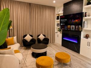 a living room with a couch and chairs and a fireplace at Emerald - 10mins from Stampede Park in Calgary