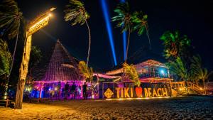 a nightclub on the beach at night at Tiki Beach Club & Resort in Paje