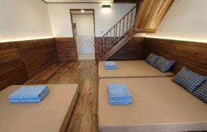 two beds in a room with a staircase at Home stay TB in Palayangan