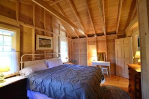 a bedroom with a bed in a room with wooden walls at Berry Cottage, private dock, overlooking a sandy b in South Thomaston