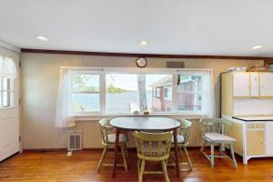 a kitchen with a table and chairs and a window at Secluded lakefront cottage great views, dock & boat launch in Ellsworth +11 photos