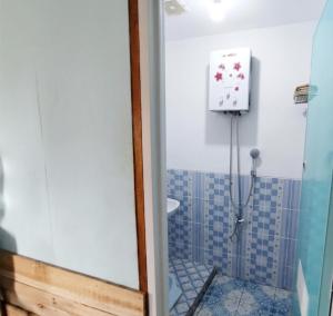 a bathroom with a shower with a toilet and a sink at Home stay TB in Palayangan