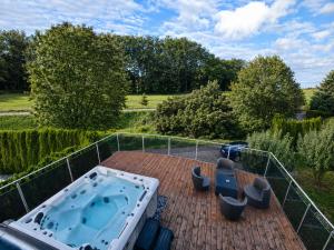 a hot tub on the deck of a house at Villa with Pool - Leon's Holiday Homes in Dottikon