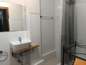a white bathroom with a sink and a shower at Casa Montse - Derecha in Colombres