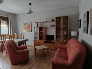 a living room with two chairs and a table at Casa Montse - Derecha in Colombres